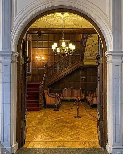 El hall de entrada: boiserie, escalera de madera y piso de roble